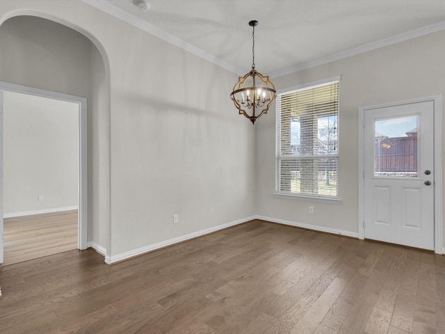 interior space featuring a notable chandelier, baseboards, dark wood finished floors, and crown molding