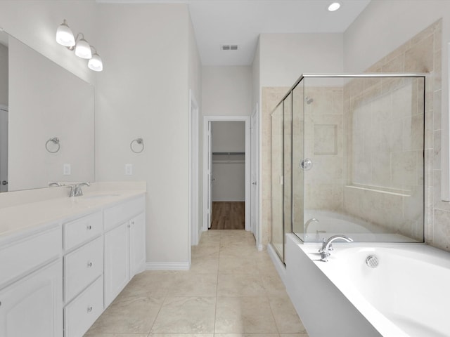 full bathroom featuring a garden tub, vanity, visible vents, a spacious closet, and a shower stall