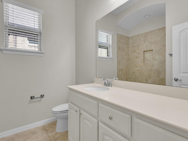 bathroom with toilet, vanity, a wealth of natural light, and tile patterned floors