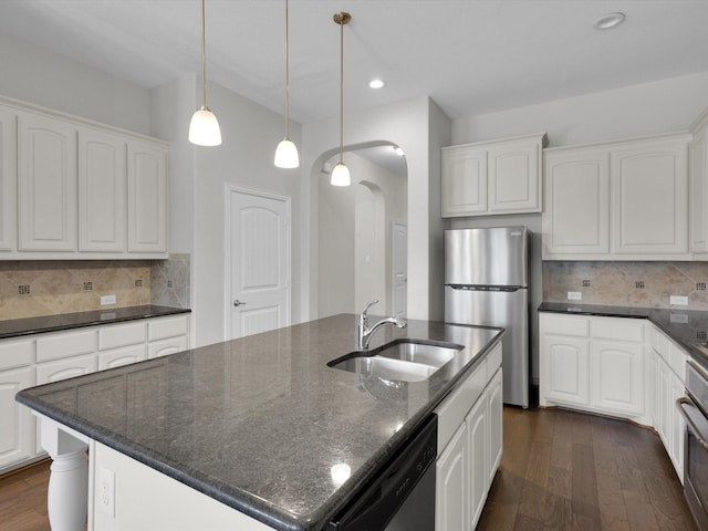 kitchen featuring dark wood finished floors, arched walkways, stainless steel appliances, and a sink