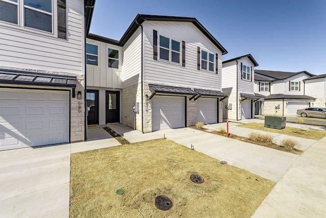 view of property with concrete driveway, board and batten siding, and an attached garage