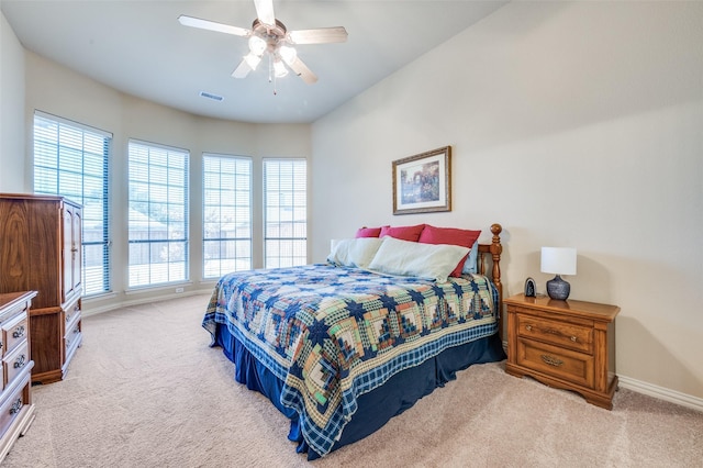 bedroom featuring light carpet, ceiling fan, visible vents, and baseboards