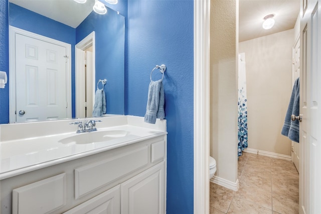 full bath with vanity, tile patterned flooring, toilet, and baseboards