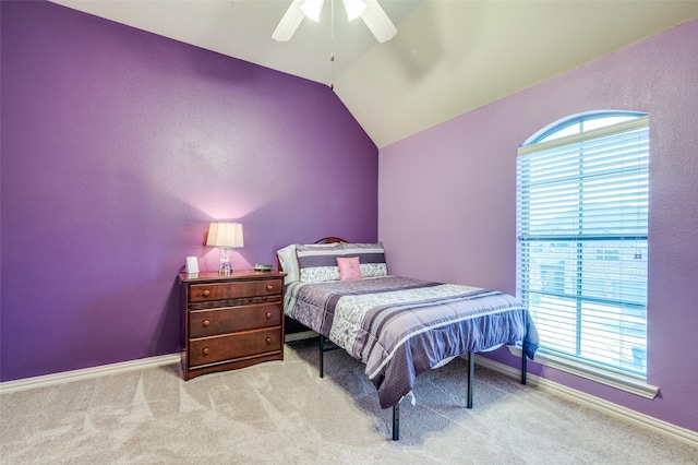 bedroom featuring light carpet, baseboards, vaulted ceiling, and a ceiling fan