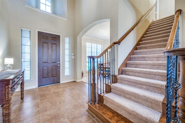 entryway featuring a wealth of natural light, baseboards, and a high ceiling