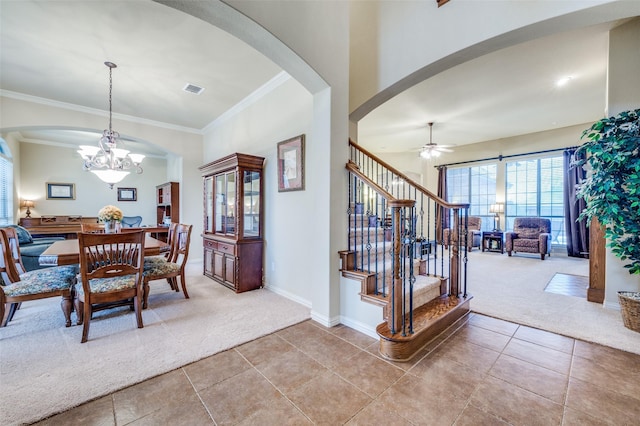 dining room featuring arched walkways, light carpet, visible vents, ornamental molding, and stairway