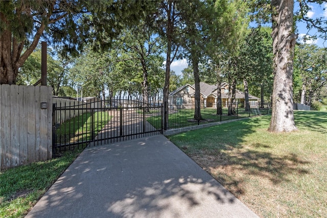 view of gate with a lawn and fence