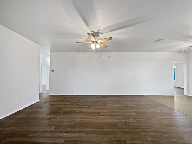 empty room featuring dark wood-style floors, visible vents, and a ceiling fan