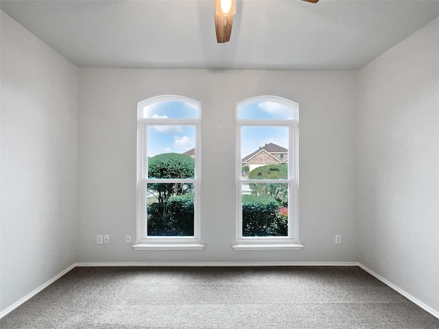 empty room with carpet flooring, ceiling fan, and baseboards