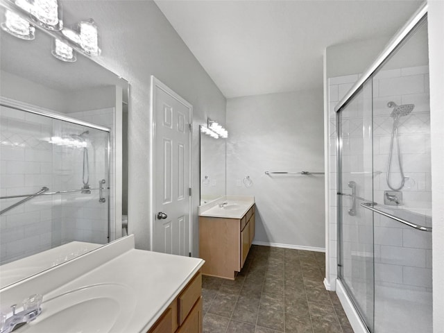 bathroom with baseboards, two vanities, a sink, and a shower stall