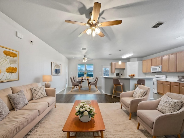 living room with light wood-style floors, baseboards, and visible vents