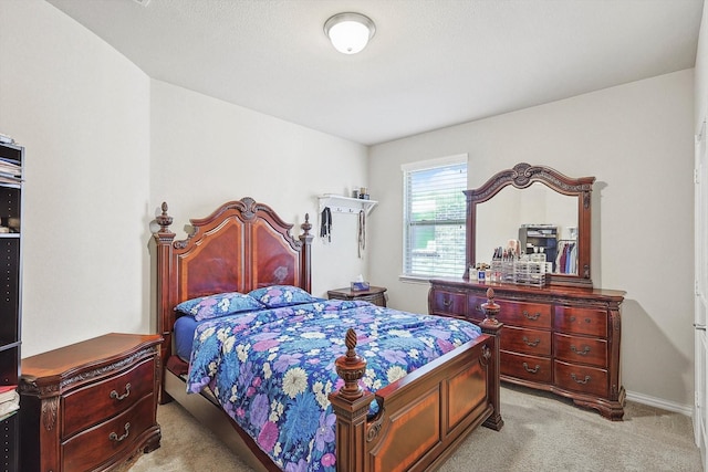 bedroom featuring light carpet and baseboards