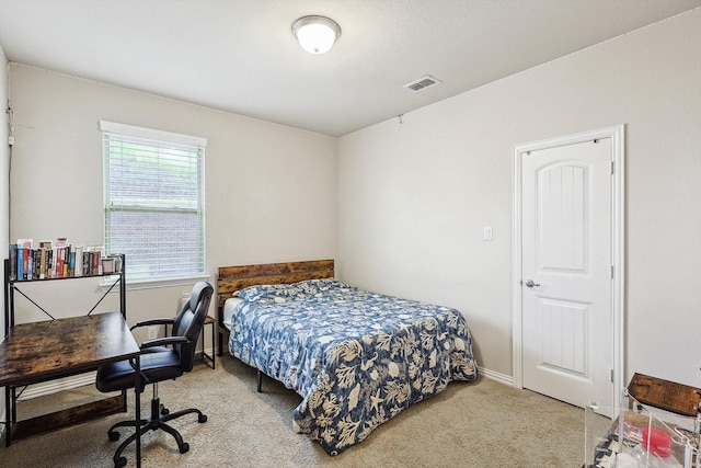 bedroom with baseboards, visible vents, and light colored carpet