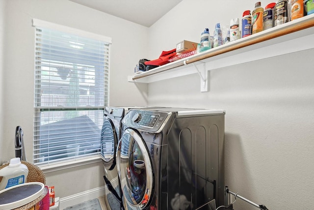 laundry area featuring laundry area, washing machine and dryer, and baseboards