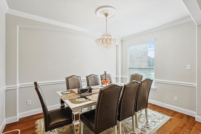 dining area featuring crown molding, dark wood-type flooring, a notable chandelier, and baseboards