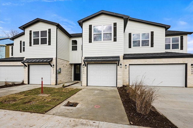 multi unit property featuring a garage and concrete driveway