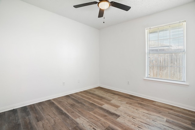 unfurnished room with a ceiling fan, a textured ceiling, baseboards, and wood finished floors