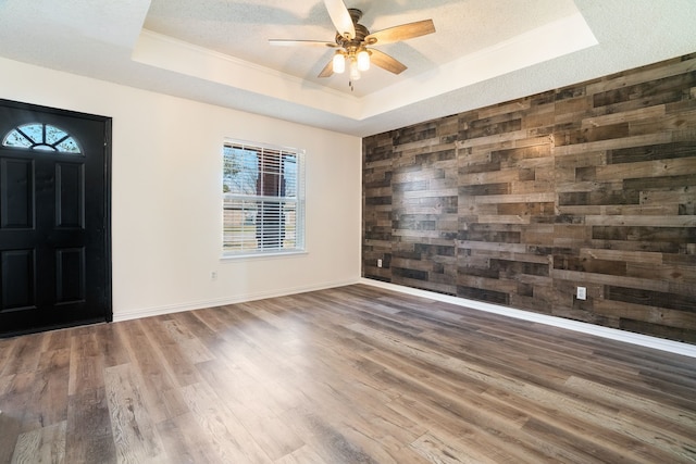 entryway with dark wood-style floors, a tray ceiling, a textured ceiling, and baseboards