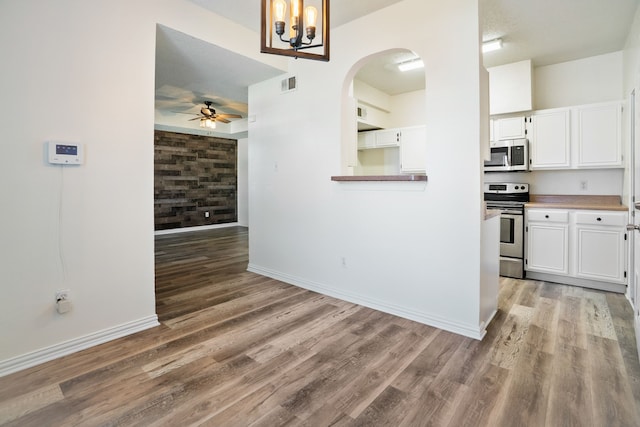 kitchen featuring visible vents, appliances with stainless steel finishes, wood finished floors, and white cabinetry