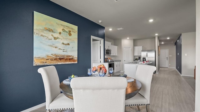 dining space featuring recessed lighting and baseboards