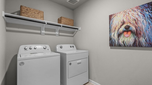 clothes washing area featuring laundry area, washing machine and dryer, visible vents, and baseboards