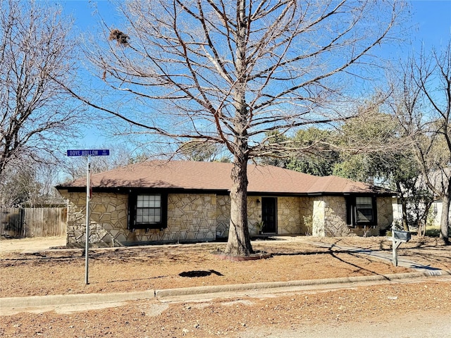 single story home with stone siding and fence