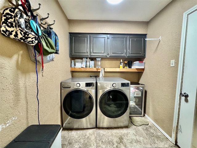 washroom with a textured wall, cabinet space, independent washer and dryer, and baseboards