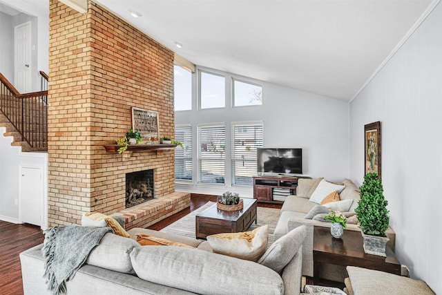 living area featuring dark wood-style floors, baseboards, a fireplace, and high vaulted ceiling