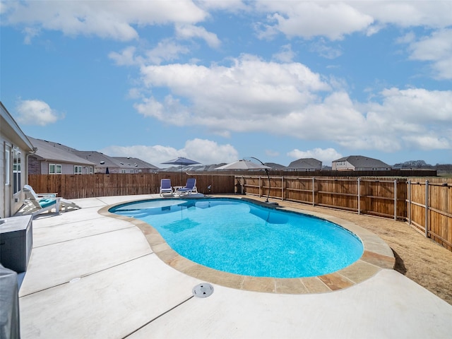 view of swimming pool featuring a fenced in pool, a residential view, a patio area, and a fenced backyard