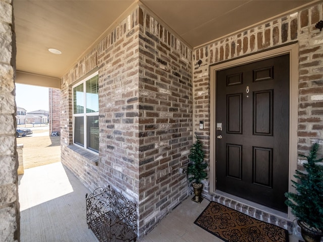 entrance to property featuring brick siding