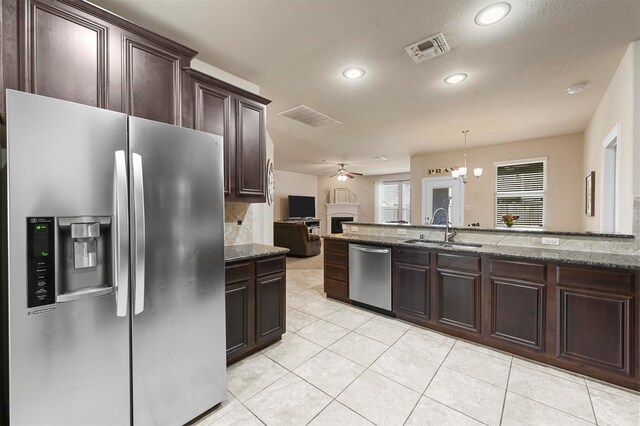 2601 Sabine Cir, Royse City, TX 75189 - kitchen with appliances with stainless steel finishes, a sink, a ceiling fan, dark brown cabinetry, and stone countertops