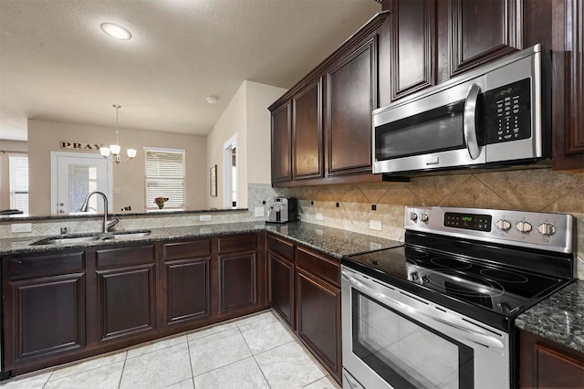 2601 Sabine Cir, Royse City, TX 75189 - kitchen with appliances with stainless steel finishes, a sink, dark stone counters, tasteful backsplash, and a textured ceiling