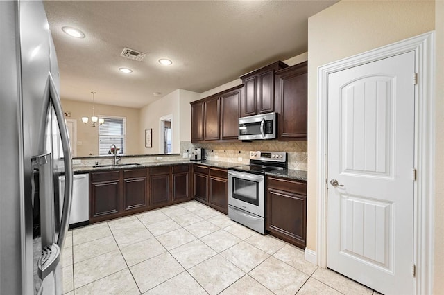 2601 Sabine Cir, Royse City, TX 75189 - kitchen featuring stainless steel appliances, a sink, decorative backsplash, dark brown cabinetry, and a chandelier