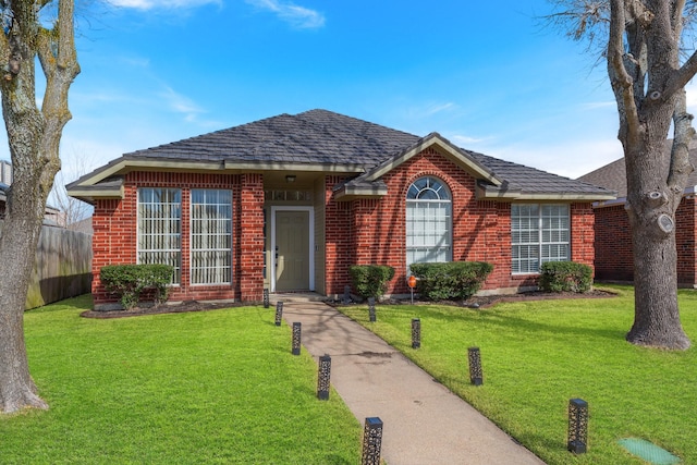 ranch-style house with brick siding, fence, and a front lawn