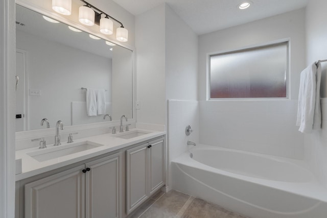 bathroom with tile patterned flooring, a garden tub, a sink, and double vanity