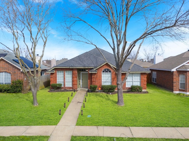 view of front of home featuring fence, a front lawn, and brick siding