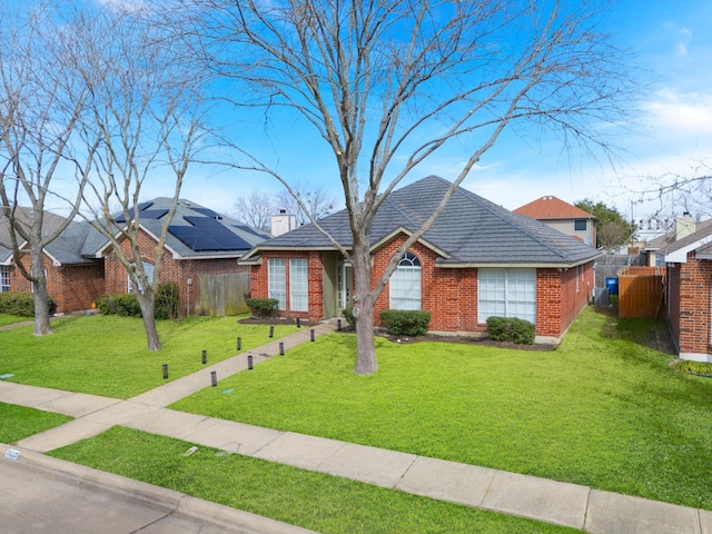 single story home with brick siding, fence, a chimney, and a front lawn