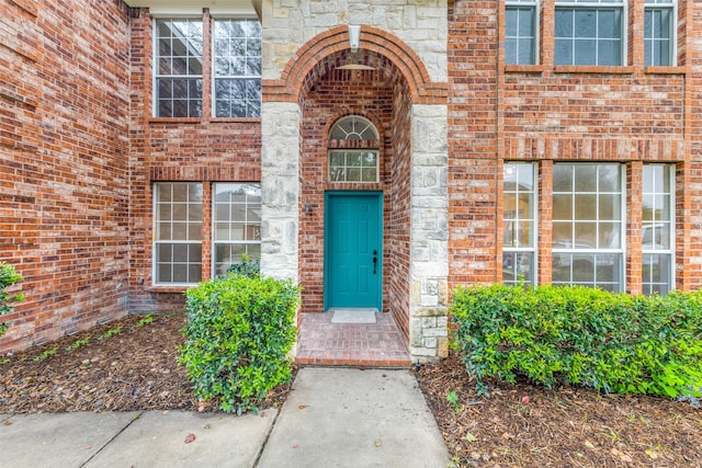 entrance to property with stone siding and brick siding