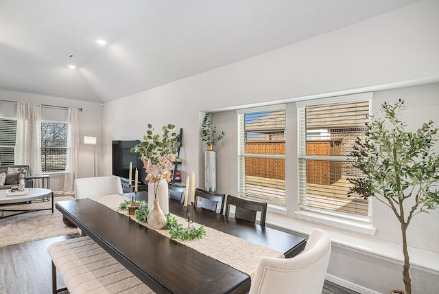 dining area featuring baseboards, visible vents, lofted ceiling, wood finished floors, and recessed lighting