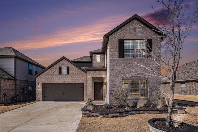 traditional-style house featuring concrete driveway, brick siding, and an attached garage