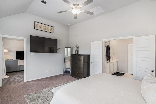 bedroom with baseboards, visible vents, light colored carpet, ensuite bathroom, and vaulted ceiling