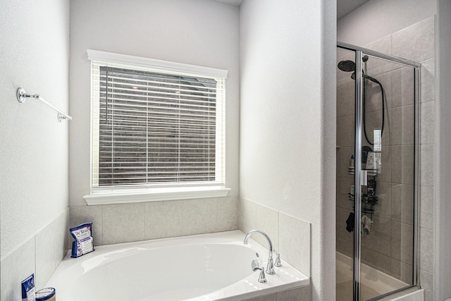 full bathroom featuring a garden tub and a shower stall