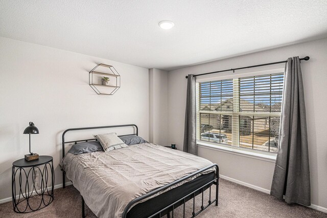 bedroom featuring a textured ceiling, carpet flooring, and baseboards