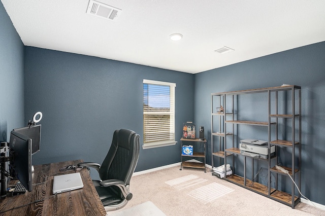 carpeted office space featuring visible vents and baseboards