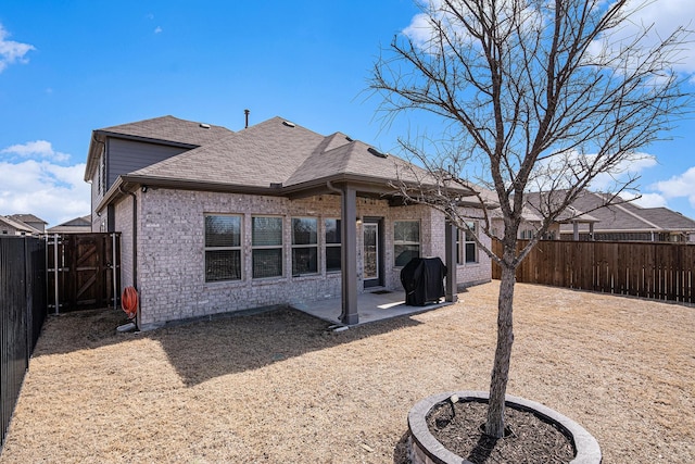 back of house featuring brick siding, a patio area, and a fenced backyard