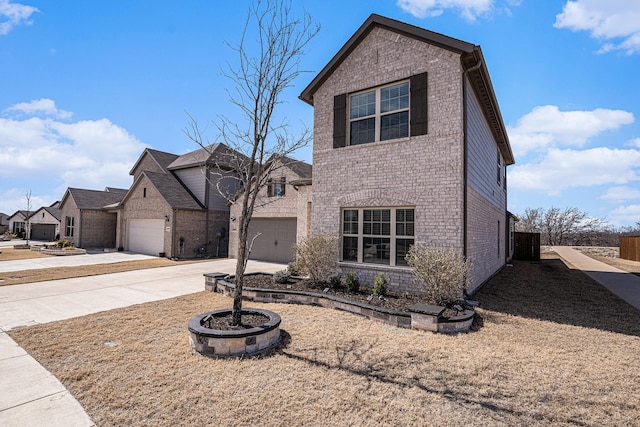 traditional-style house with a garage, concrete driveway, and brick siding