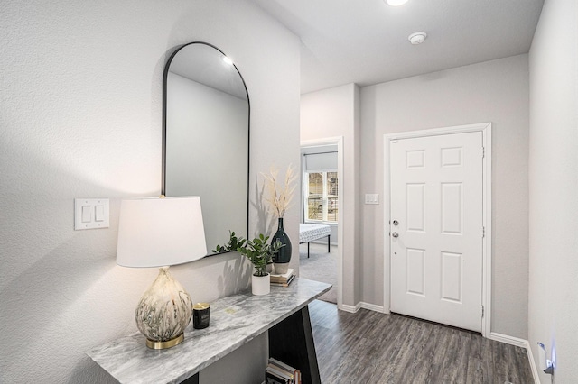 entrance foyer with dark wood finished floors and baseboards