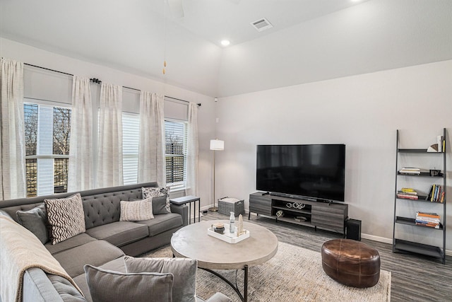 living area featuring lofted ceiling, wood finished floors, visible vents, and baseboards