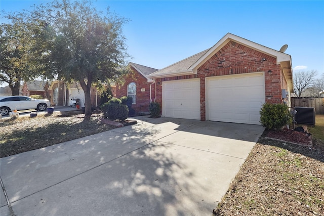 single story home with a garage, brick siding, driveway, and central AC unit