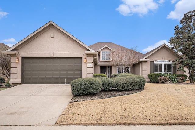 view of front of property featuring concrete driveway, an attached garage, and stucco siding